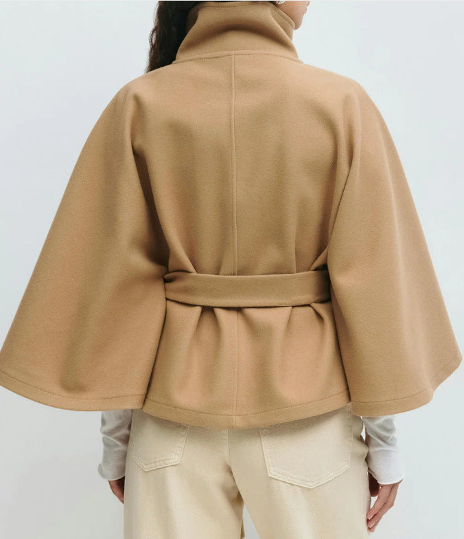 Woman in belted cape coat with high collar